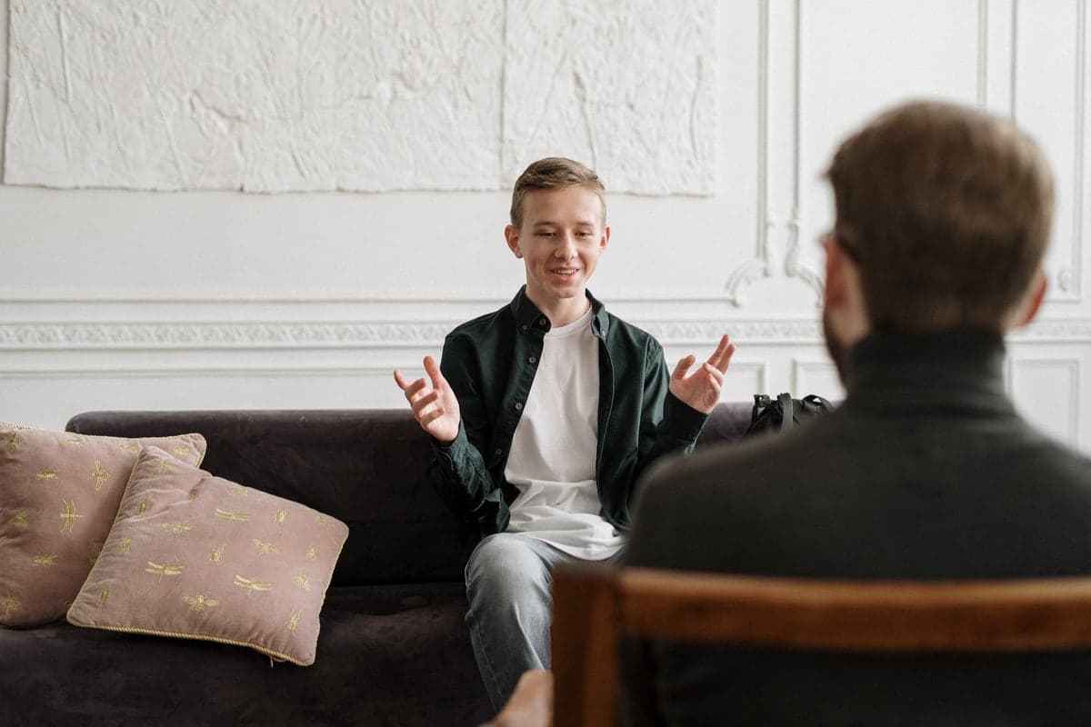 A smiling teenager talking with a counselor